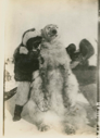 Image of Polar Bear held up by two Eskimos [Inuit]